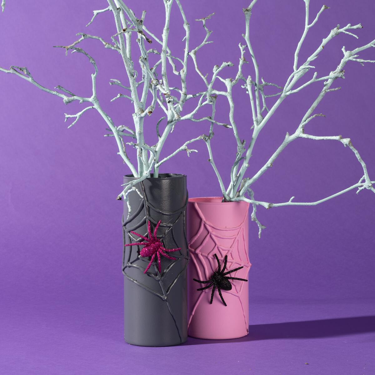 Vases in grey and pink colors decorated with spider web and spiders