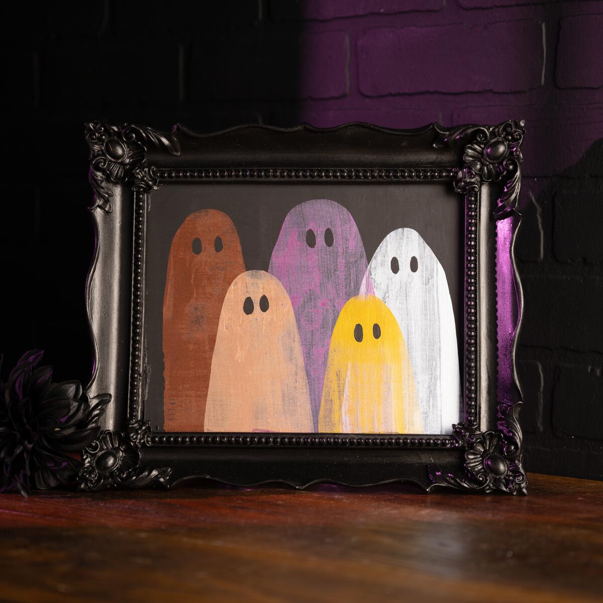 Black frame with metallic ghost figures in a family portrait style