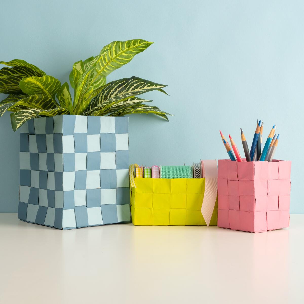 Baskets woven with strips of paper and painted with FolkArt Acylic Paints. Used for storing art supplies and plants.