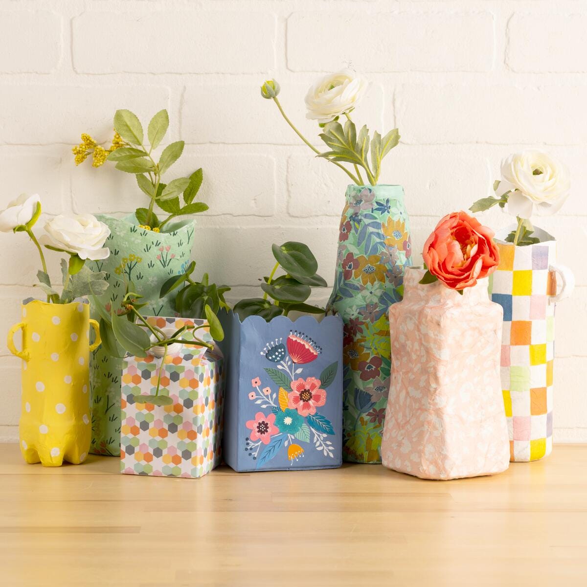 Upcycled containers made into vases and decoupaged with Mod Podge and floral designs