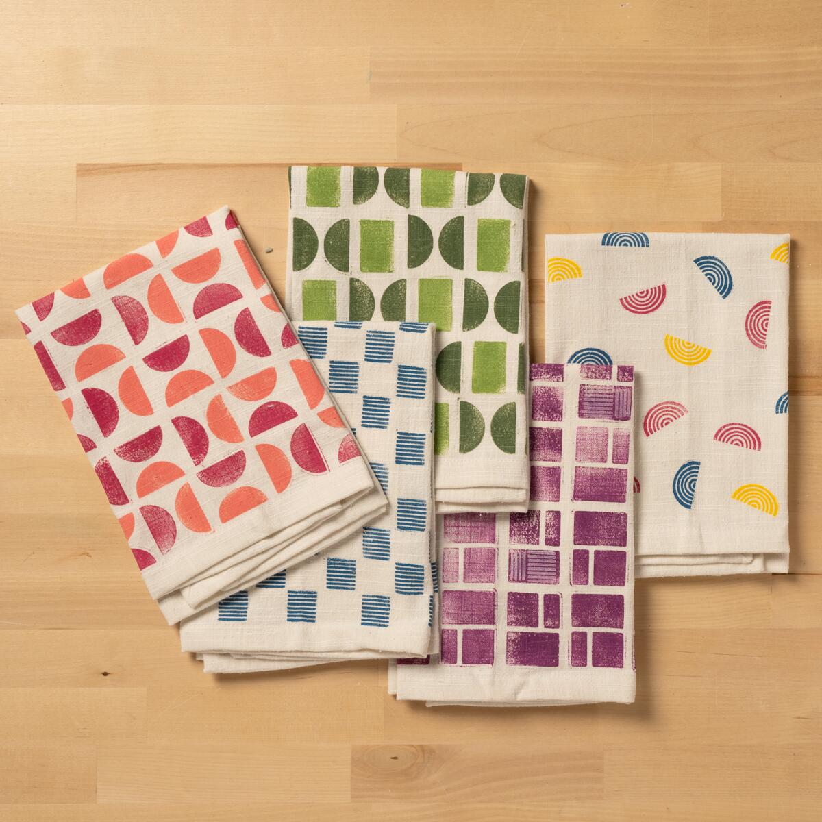 A flat lay of colorfully stamped tea towels