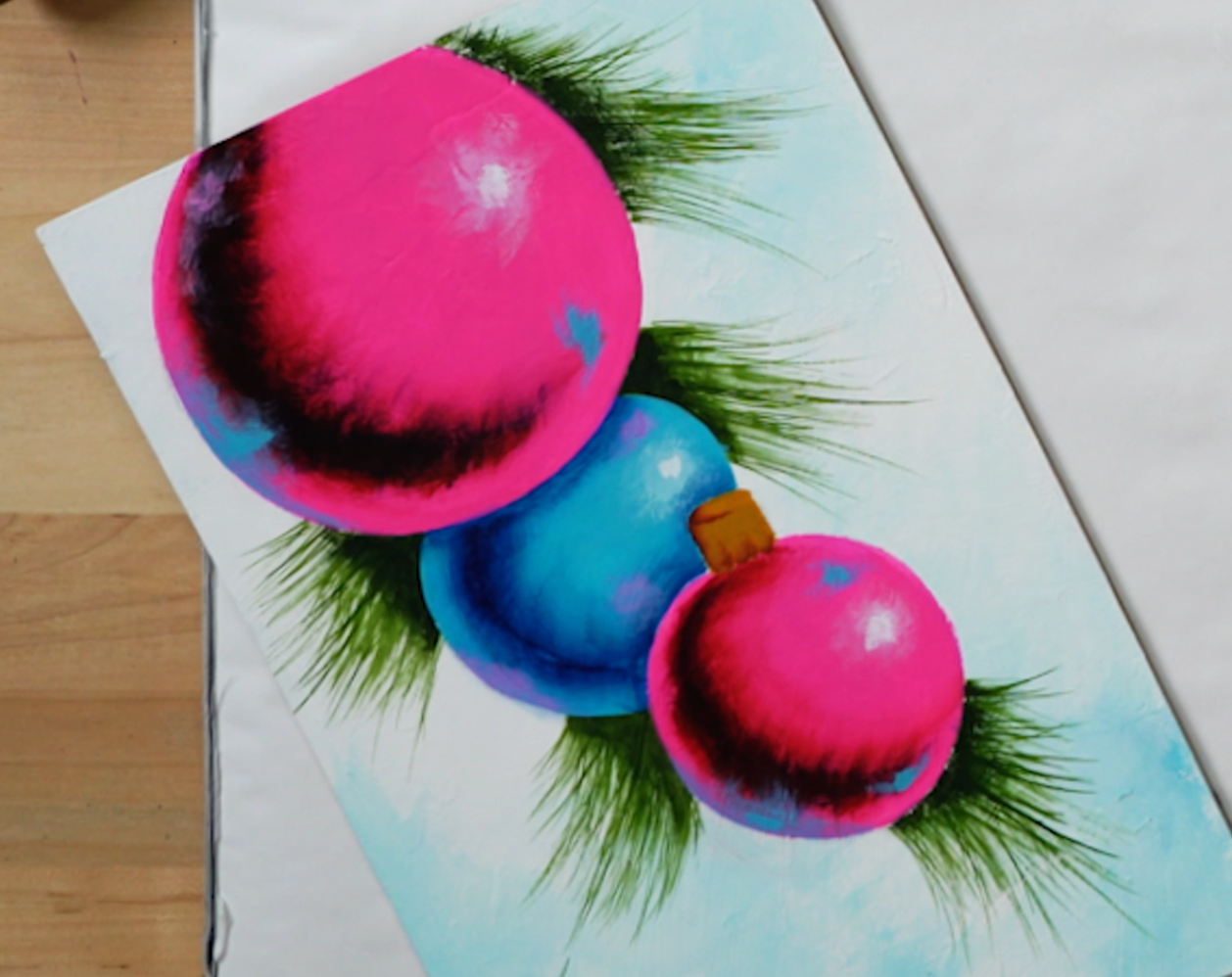 Painting of pink and blue ornaments on an art studio desk